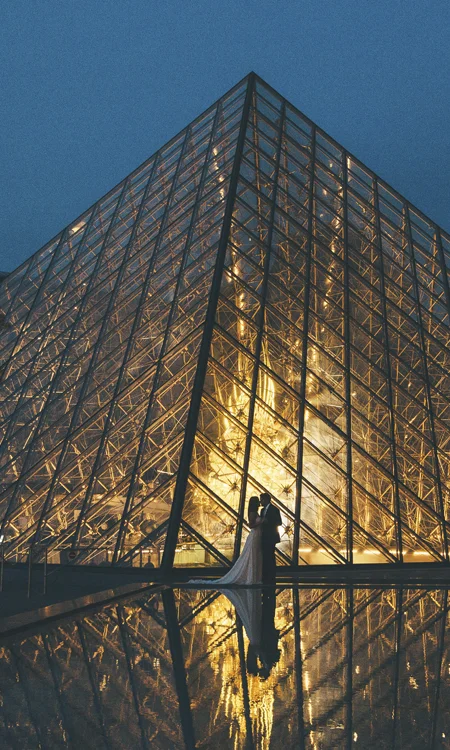 imagen de novios abrazados en el exterior del museo Louvre de París