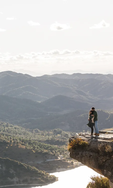 novios al borde de acantalidado abrazados mirando el paisaje